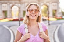 Happy female standing in sunshine during trip in Madrid and looking at camera — Stock Photo