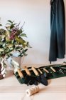 Truelles métalliques assorties avec houe et fourchette de jardinage près du vase avec plante à la maison — Photo de stock