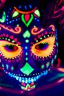 Anonymes Weibchen in bunter Maskerade mit Blumen auf dem Kopf blickt in der Halloween-Nacht in die Kamera — Stockfoto
