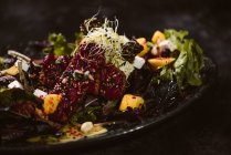 Тарелка с вкусным вегетарианским индонезийским салатом со свежим манго и ломтиками кешью рядом с соевыми бобами и приправами, покрытыми базиликовым винегретом — стоковое фото