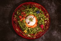 Vista aerea del gustoso burrata su crema di pomodoro freddo con foglie di rucola e pomodorini con tartufo e arachidi — Foto stock