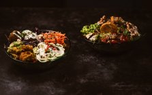 Appetitliche vegetarische Bio-Gerichte mit verschiedenen Gemüsesorten auf rustikalem, dunklem Tisch — Stockfoto