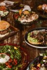 Вигляд вегетаріанських страв з грибами та овочами біля бургера та морозива з французьким тостом на дерев'яному столі. — стокове фото