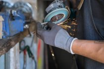 Cultiver mécanicien masculin dans des gants réparer vélo dans un atelier moderne — Photo de stock
