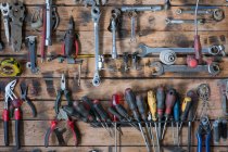 Набір різних залізних інструментів для ремонту на стіні з пиломатеріалів в сучасній майстерні — стокове фото