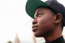 Baixo ângulo de jovem afro-americana em desgaste casual olhando para a câmera com o dedo para cima à luz do dia — Fotografia de Stock