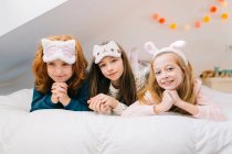 Fröhliche Kinder ruhen sich im Schlafzimmer auf dem Bett aus, während sie das Wochenende zusammen verbringen — Stockfoto