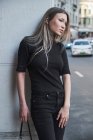 Красивая блондинка, позирует в китайском центре города в черной одежде — стоковое фото
