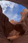 Живописный вид дуги скалистого образования, расположенного среди грубых скал в засушливом районе национального парка США против облачного неба — стоковое фото