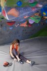 Зверху жінка альпіністка в спортивному одязі кладе професійне взуття під час підготовки до тренувань — стокове фото