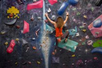 Rückenansicht einer starken Sportlerin in Sportbekleidung Kletterwand im modernen Boulderzentrum — Stockfoto