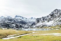 Paysage incroyable d'une chaîne de montagnes rude et sévère avec des pentes dans la neige et un lac gelé froid sur le fond par temps clair d'hiver — Photo de stock