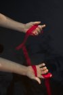 Vista dall'alto di crop viaggiatore femminile anonimo con braccia raggiunte dimostrando benda rossa in acqua su sfondo nero — Foto stock
