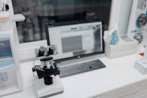 Зверху мікроскоп біля комп'ютера з відкритою програмою на екрані у ветеринарній лабораторії — стокове фото