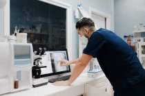 Crop veterinário anônimo mostrando imagem de raios X na tela do computador enquanto trabalhava em laboratório — Fotografia de Stock