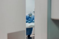 Veterinário masculino focado em máscara uniforme e respiratória usando instrumentos médicos durante a cirurgia no hospital — Fotografia de Stock