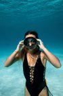 Sottile femmina in costume da bagno e pinne nuotare sott'acqua in mare turchese — Foto stock