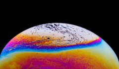 Vista panorâmica da bolha de closeup fundo texturizado representando planeta colorido com linhas onduladas na superfície redonda em forma de fundo preto — Fotografia de Stock