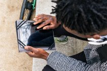 Blick von oben auf junge afroamerikanische Manager mit Tablet und Headset, die gegen städtisches Bauen weglaufen — Stockfoto