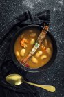 Dall'alto di appetitosa zuppa di panna con fagioli bianchi e langoustines serviti in ciotola e disposti su piano di marmo vicino al tovagliolo in cucina — Foto stock