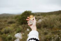 Урожай анонимных женщин-туристов с помощью компаса на горе с грубыми камнями при дневном свете — стоковое фото