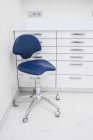 Elegante design degli interni della sala clinica luce contemporanea con mobili bianchi e sedia blu — Foto stock