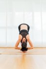 Corps complet de femme sans visage méditant dans Big Toe asana pendant la pratique du yoga sur tapis de sport en studio — Photo de stock