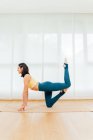 Vista lateral cuerpo completo de deportista descalzo enfocado estirando el cuerpo y mejorando la resistencia durante la práctica de yoga - foto de stock