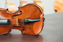Сучасна блискуча скрипка, розміщена на міцному дерев'яному столі в майстерні — стокове фото