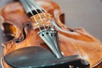 From above of modern shiny violin placed on shabby wooden table in workshop — Stock Photo
