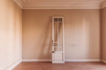Білі дерев'яні двері з шорсткою поверхнею поміщені в стару порожню кімнату вдень — стокове фото