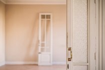 Porta aberta de madeira branca antiquada com alças ornamentais em estilo retro em apartamento vazio — Fotografia de Stock