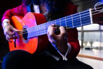 Crop musicista maschile seduto sulla sedia e suonare la chitarra durante le prove sul palco — Foto stock