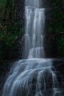 Veduta pittoresca di una piccola cascata che scorre attraverso la foresta a Cascada de Oneta nelle Asturie, Spagna — Foto stock