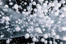 Draufsicht auf erstaunliche gefrorene Methanblasen unter Wasser des eisigen Baikalsees im Winter als abstrakter Hintergrund — Stockfoto