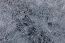 De cima da superfície congelada do Lago Baikal com padrão caótico e rachaduras como fundo abstrato — Fotografia de Stock