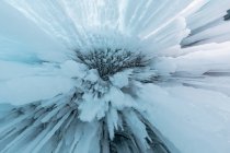 D'en bas d'énormes glaçons suspendus à la grotte rocheuse près du lac Baïkal en hiver comme fond abstrait — Photo de stock