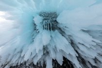 Von unten riesige Eiszapfen, die im Winter als abstrakter Hintergrund in einer Felshöhle in der Nähe des Baikalsees hängen — Stockfoto