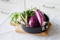 Berinjelas frescas com cebola verde colocadas na mesa para cozinhar o almoço vegetariano saudável em casa — Fotografia de Stock
