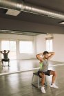 Seitenansicht eines ernstzunehmenden jungen, fitten athletischen Mannes in aktiver Kleidung, der während des Trainings im Studio eine Kniebeuge auf der Trittplattform macht — Stockfoto