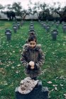 Angolo alto di piccolo bambino che piange la morte di soldato che combatte in guerra a cimitero — Foto stock
