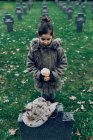 Ângulo alto de morte de luto de criança pequena de soldado que luta na guerra no cemitério — Fotografia de Stock
