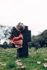 National American flag and army flag placed on gravestone in military cemetery on early autumn day — Stock Photo