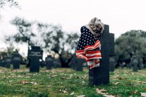 Государственный американский флаг и армейский флаг помещены на надгробии на военном кладбище в ранний осенний день — стоковое фото