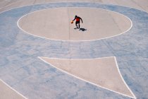 Сверху баскетболист бегает с мячом на бетонной площадке во время тренировок в солнечный день — стоковое фото