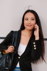 Conteúdo Empresária asiática falando no smartphone enquanto discute o projeto de negócios e olha para longe — Fotografia de Stock
