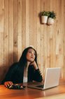 Зайнята азіатська жінка-підприємець сидить за столом у кафе і їсть суші і працює над віддаленим проектом через нетбук. — стокове фото