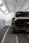 Modernes kaputtes Auto parkt in heller Metallhalle der Kfz-Werkstatt — Stockfoto