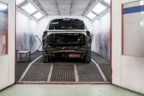 Moderno coche roto estacionado en las instalaciones de metal brillante de la estación de servicio de reparación de automóviles - foto de stock