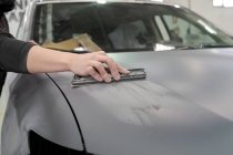 Майстер обрізання чоловічої статі в брудному робочому одязі буферизації автомобіля під час підготовки автомобіля до фарбування в ремонті — стокове фото